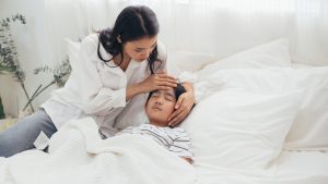 asian mother sitting with sick son